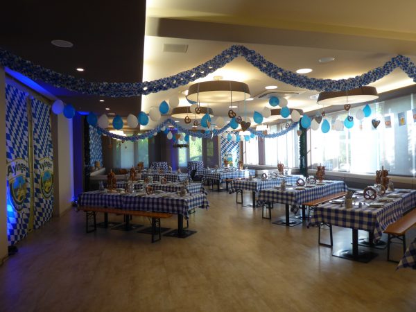 Eventrestaurant festlich dekoriert zum Oktoberfest in Blau-weiß mit Bierbänken für ein Event